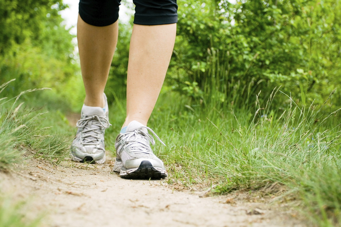 Woman walking on trail in forest