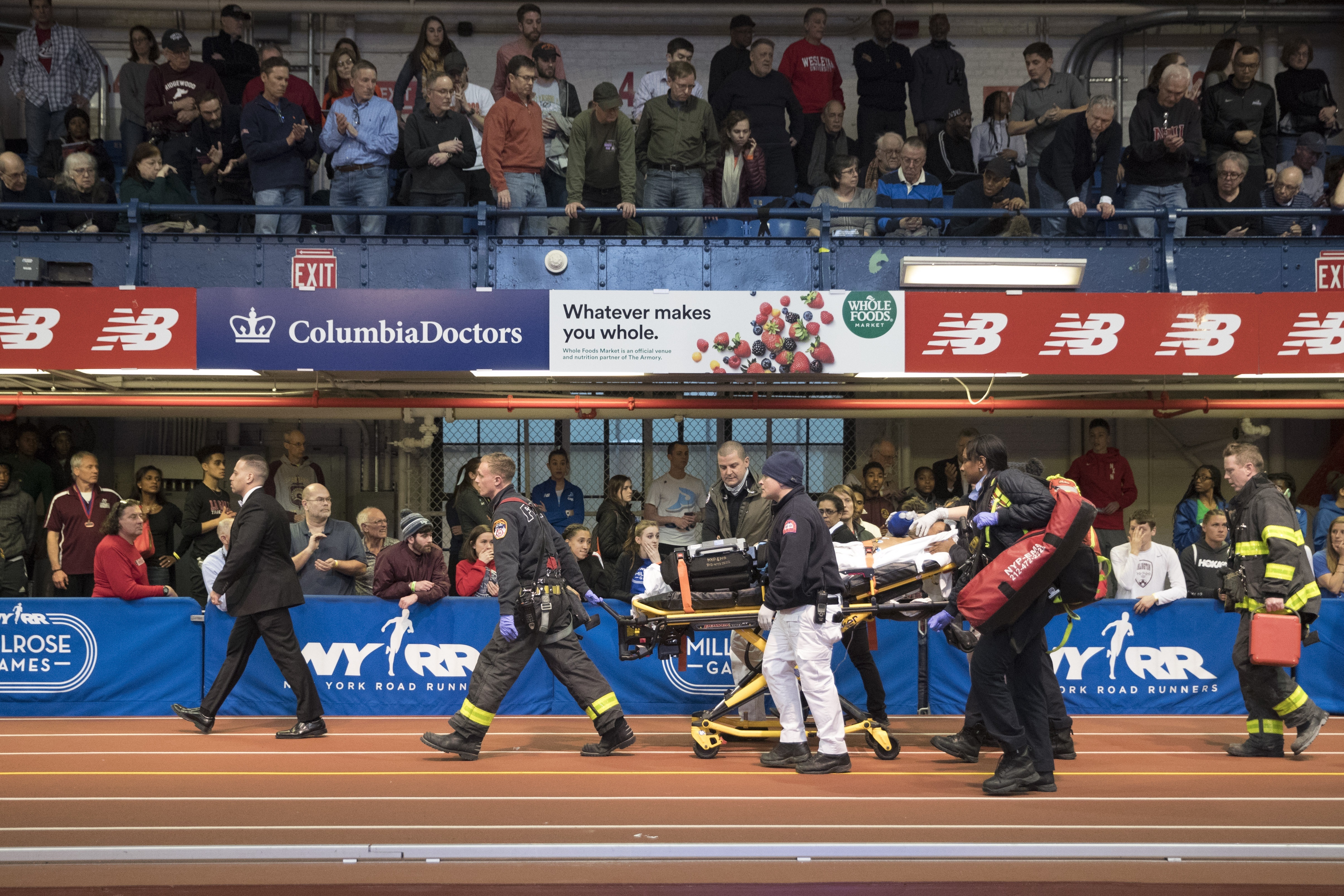 Emergency Service personnel remove Kemoy Campbell, of Jamaica, from the track after he collapsed during his duty as a pacesetter in the men's 3000-meter race at the Millrose Games track and field meet, Saturday, Feb. 9, 2019, in New York. (AP Photo/Mary Altaffer)